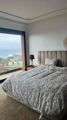 a bedroom with a large bed with a large window at Beachfront Villa in Dar Bouazza in Dar Bouazza