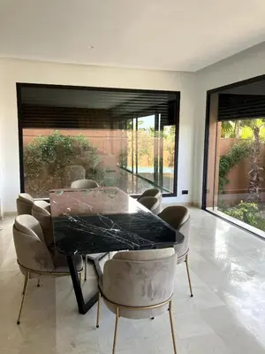 a dining room with a black table and chairs at Beachfront Villa in Dar Bouazza in Dar Bouazza