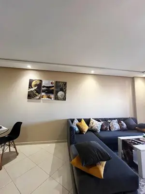 a living room with a blue couch and a table at Modern studio near stadium Mohamed V AFCON 2025 in Casablanca