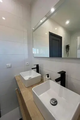 a white bathroom with a sink and a mirror at Mansouria Ricoflores beach vue mer et piscine in Mansouria