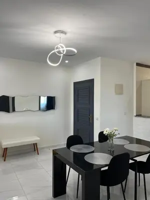 a dining room with a black table and chairs at Mansouria Ricoflores beach vue mer et piscine in Mansouria