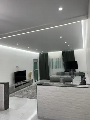 a living room with a couch and a flat screen tv at Mansouria Ricoflores beach vue mer et piscine in Mansouria
