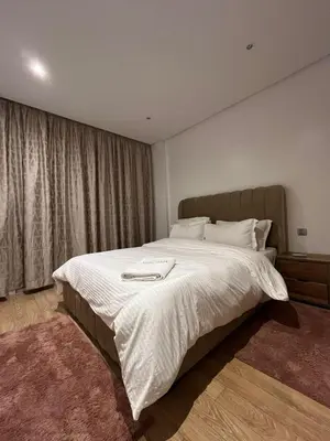 a bedroom with a large bed with white sheets at Appartement luxueux prestigia in Rabat