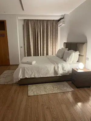 a bedroom with a large bed and a window at Appartement luxueux prestigia in Rabat