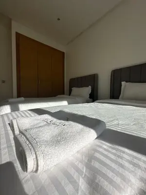 a bedroom with two beds with white towels on them at Appartement luxueux prestigia in Rabat