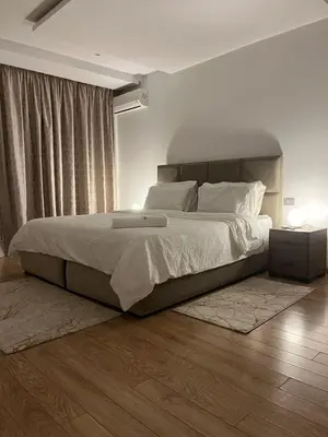 a bedroom with a large bed with white sheets and pillows at Appartement luxueux prestigia in Rabat