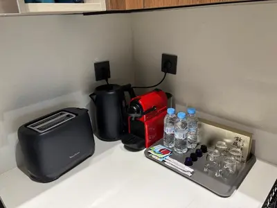 a counter with a coffee maker and water bottles on it at Elegance & Comfort - Les Princesses District in Casablanca