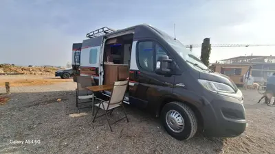 a black truck with a table and chairs next to it at J-L Camping Car Morocco in Casablanca