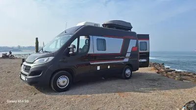 a black truck parked on the beach near the water at J-L Camping Car Morocco in Casablanca