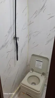 a small bathroom with a toilet and a black umbrella at J-L Camping Car Morocco in Casablanca
