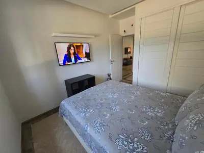 a bedroom with a bed and a tv on the wall at Les Perles de Bentriaa Mohammedia in Mohammedia