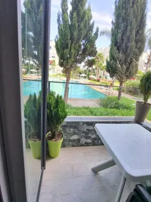 a patio with a table and a view of a pool at Les Perles de Bentriaa Mohammedia in Mohammedia