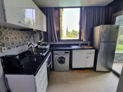 a kitchen with a refrigerator and a washing machine at Les Perles de Bentriaa Mohammedia in Mohammedia