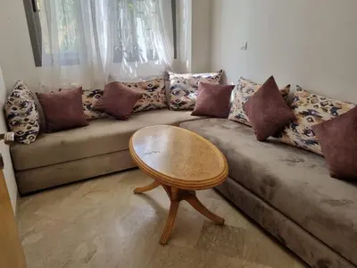 a living room with a couch with a wooden table at Les Perles de Bentriaa Mohammedia in Mohammedia
