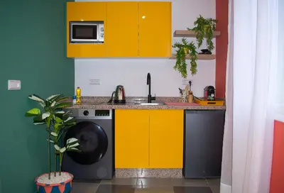 a kitchen with yellow cabinets and a washing machine at In the Heart of Casablanca in Casablanca