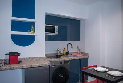 a kitchen with a washing machine and a table at In the Heart of Casablanca in Casablanca