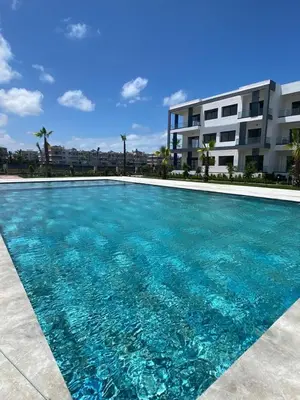 a swimming pool in front of a building at Aymen beach in Mansouria