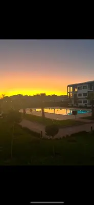 a sunset in a city with a building and trees at Aymen beach in Mansouria