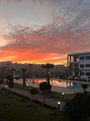 a sunset over a swimming pool in a city at Aymen beach in Mansouria