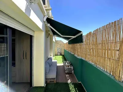 a patio with a couch under awning at Appt Centre ville Casablanca Maarif avec Terrasse in Casablanca