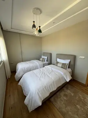 two beds in a room with white sheets at Ksar Labhar Second Nest in Rabat