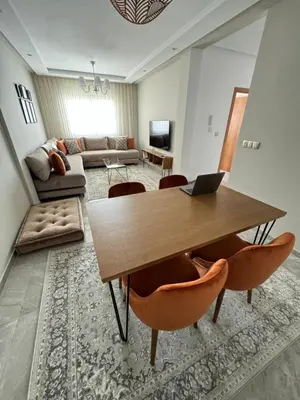 a living room with a wooden table and chairs at Ksar Labhar Second Nest in Rabat