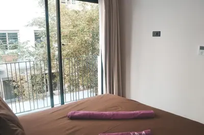 a bed with two purple pillows on it in front of a window at Luxueux appartement - Bourgogne, Casablanca in Casablanca