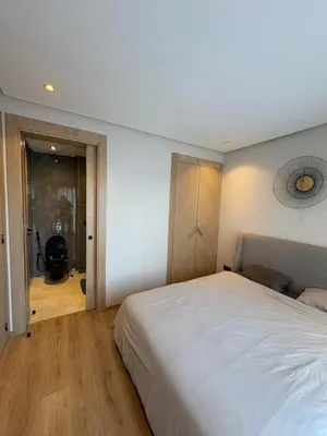 a bedroom with a large white bed and a wooden floor at Studio Prestige CFC Casablanca in Casablanca