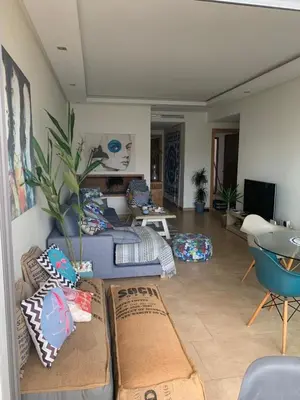 a living room filled with lots of pillows at Appartement en front de mer à 2 pas des Sablettes in Mohammedia