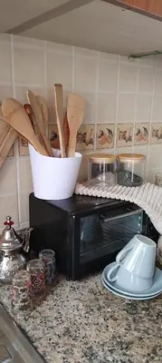 a kitchen counter with a toaster oven with wooden utensils at Appart cozy proche de casa voyageur in Casablanca