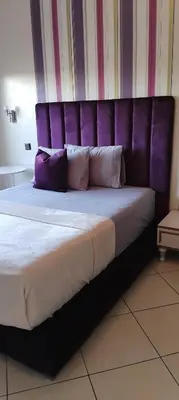a large bed with purple headboard in a room at Appart cozy proche de casa voyageur in Casablanca