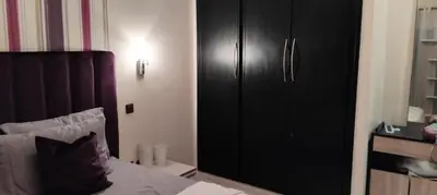 a bedroom with a black cabinet and a bed at Appart cozy proche de casa voyageur in Casablanca