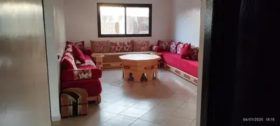 a living room with two red couches and a table at المنصورية in Mohammedia