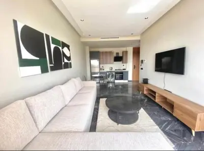 a living room with a white couch and a tv at Le 134 Square in Casablanca