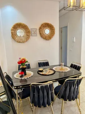a dining room with a black table and chairs at Cosy chambre salon à 2 min harhoura in Temara