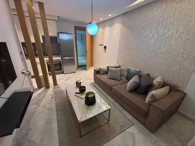 a living room with a couch and a table at Cozy studio in ain diab in Casablanca
