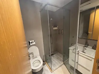 a bathroom with a toilet and a glass shower at Cozy studio in ain diab in Casablanca