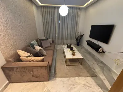 a living room with a couch and a flat screen tv at Cozy studio in ain diab in Casablanca