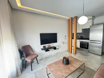 a living room with a flat screen tv on a wall at Cozy studio in ain diab in Casablanca