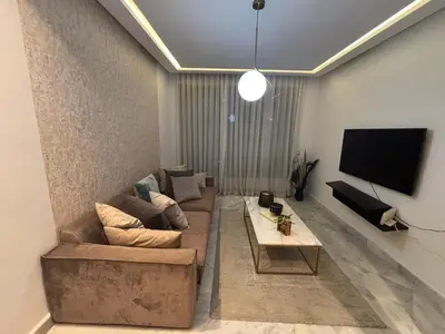 a living room with a couch and a flat screen tv at Cozy studio in ain diab in Casablanca