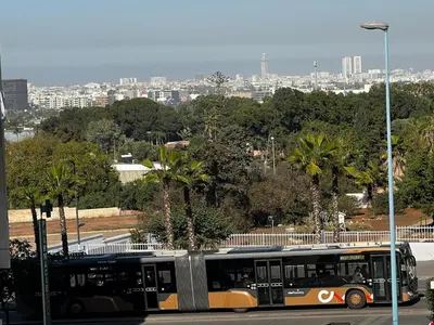 a bus parked in a parking lot with a city in the background at Apartment busway nearshore in Casablanca