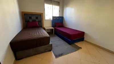 a small bedroom with two beds and a window at Apartment busway nearshore in Casablanca