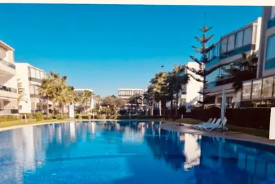a large swimming pool with blue water in a city at Blanca beach in Sidi Rahal