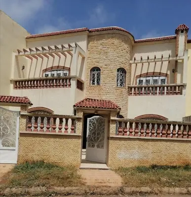 a large house with a balcony and a door at Beautiful villa Near the beach in Mohammedia