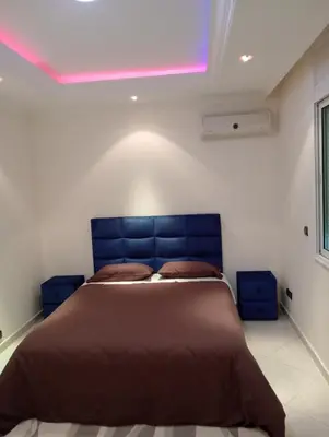 a bedroom with a large bed with a blue headboard at Beautiful villa Near the beach in Mohammedia