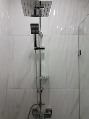 a shower in a bathroom with white tiles at Pierro in Maarif