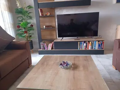 a living room with a television and a wooden coffee table at Lovely & Comfy Long and Short Stay at Nouacer-Casa 2-Bedroom Apartment in Nouaceur