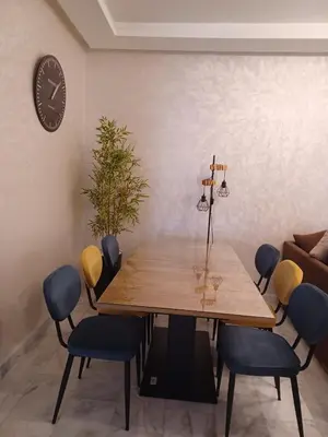 a dining room table with chairs and a clock on the wall at Lovely & Comfy Long and Short Stay at Nouacer-Casa 2-Bedroom Apartment in Nouaceur