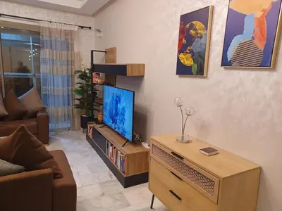 a living room with a flat screen tv and a couch at Lovely & Comfy Long and Short Stay at Nouacer-Casa 2-Bedroom Apartment in Nouaceur