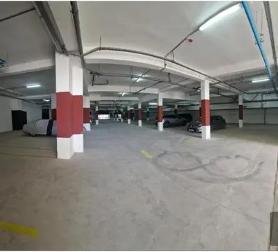 an empty parking garage with red and white columns at Beautiful apartment in the heart of Zenata in Aïn Harrouda